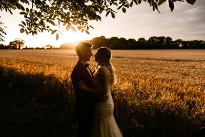 bride-and-groom-looking-at-each-other-at-sunset-tithe-barn