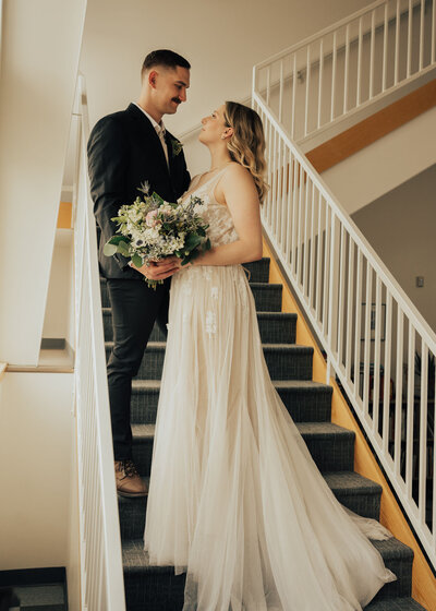Maddie Rae Photography wedding portrait of couple standing on stairs looking at eachother