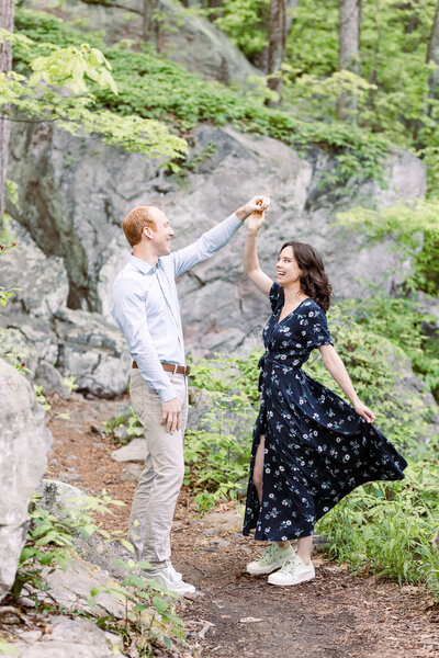 engaged couple twirling on a hiking trail in Chattanooga