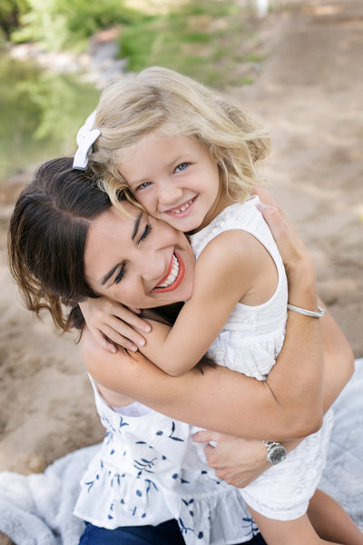 Mom and daughter embracing in a hug during a break in photo session