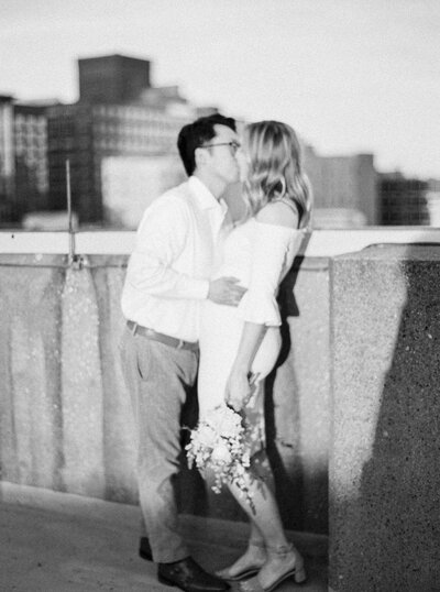 Bride and groom kiss in downtown Louisville engagement session photographed by Lexington Kentucky luxury wedding photographer Magnolia Tree Photo Company