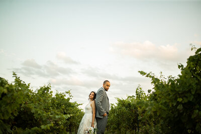 Bride and groom back to back in a vineyard on their wedding day