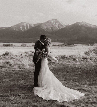 bride-and-groom-kissing-with-mountains-in-bg