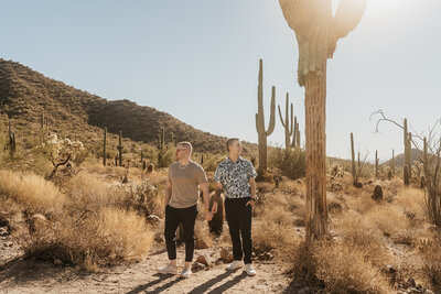 A couple holding hands and looking out opposite directions in the desert 