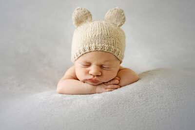 newborn-baby-posed-on-beanbag-with-beautiful-headband