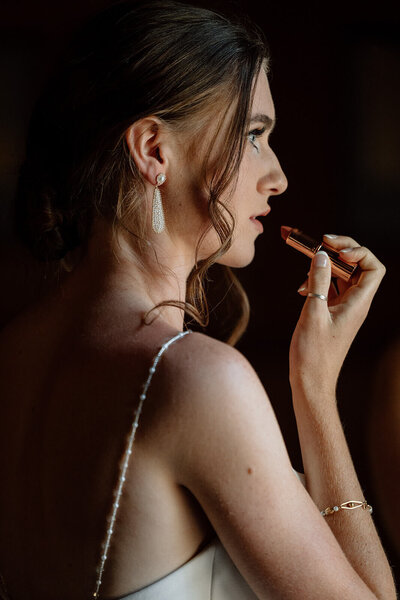 luxury bride puts on red lipstick moody