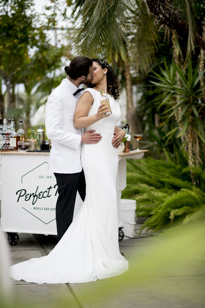 Part of Wedding Content Shoot - Couple kissing in front of bar cart - Botanic shoot