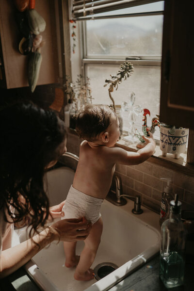baby standing in the sink in their sahuarita home