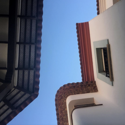 Photo taken looking up at Spanish rooftops.