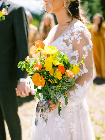 Bride holding a bouquet of wildflowers during her wedding at Glacier National Park.