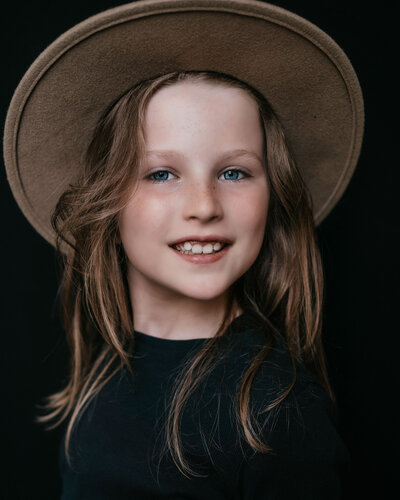 Professioneel kinderportret van een meisje met rode haren, lachend op de foto
