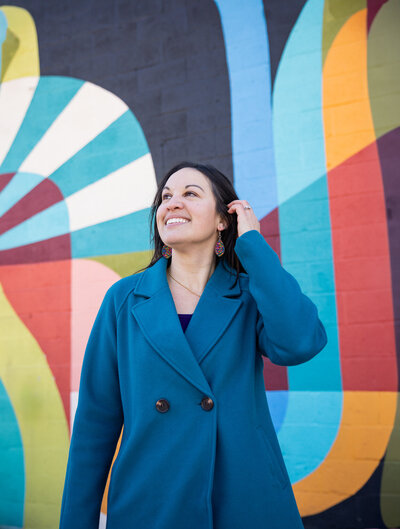 A-graphic-designer-poses-during-her-baltimore-brand-session-with-Ingrid-Berrios-photography-at-Union-Collective-with-their-colorful-wall