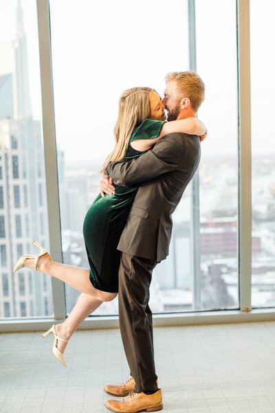 cutest couple leaping into each other's arms after their Nashville Surprise Proposal at the Pinnacle building in downtown Nashville