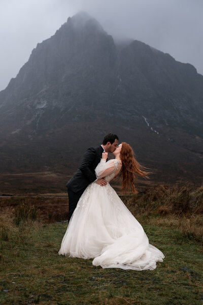 Couple from spain kiss during their scottish elopement to glencoe