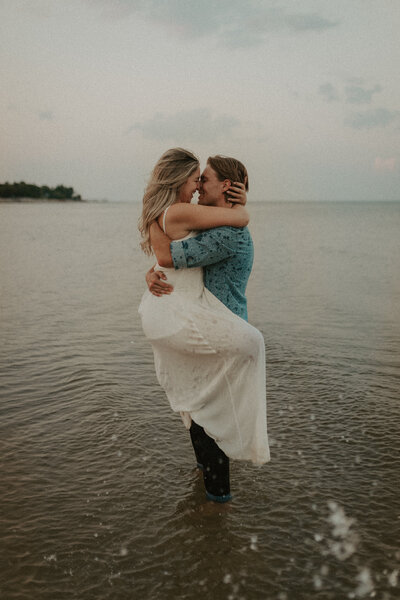 bride and groom embracing in lake