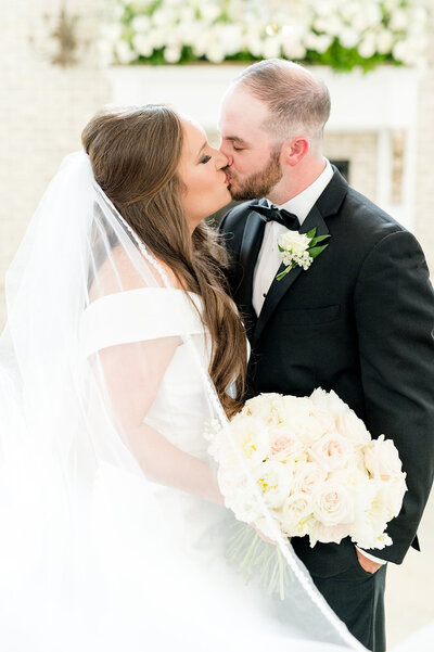 Bride and groom kiss at wedding .