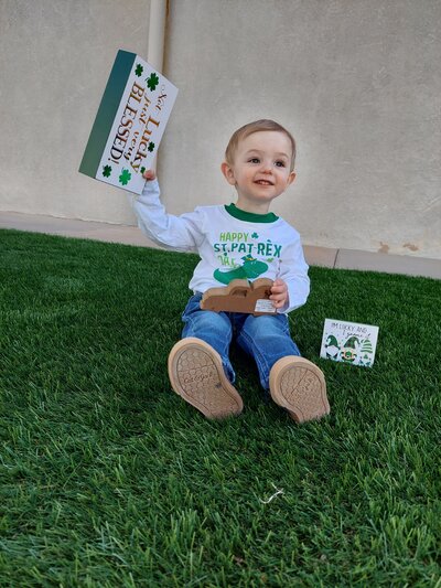 Young Boy Smiling with St Patricks Day Sign CPC Albuquerque Childcare