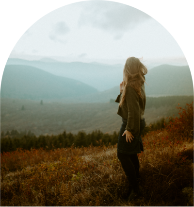 woman staring out into the mountain landscape