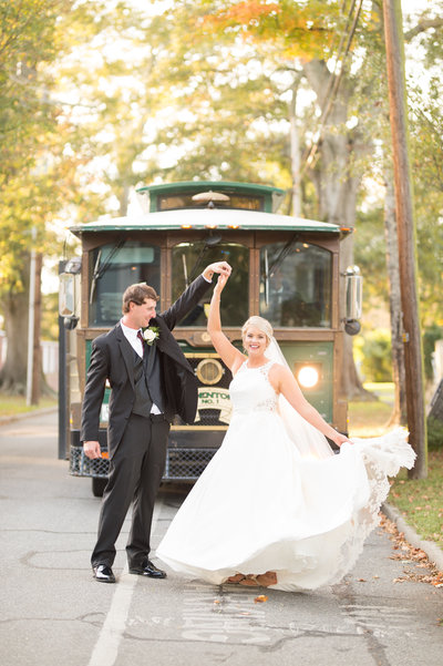 Bride and groom standing in front of a trolly