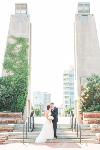 bride and groom kiss on the steps at the seaport museum in philadelphia