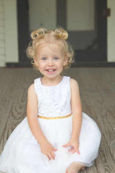 Blonde Toddler Girl in White Dress Smiling