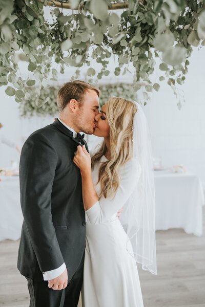 Sacramento Wedding Photographers capture bride grabbing groom's lapels and kissing him