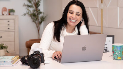photo of a brand photographer in her home office, styled with camera, laptop