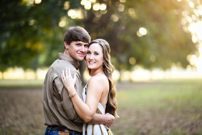 Beautiful Mississippi Engagement Photography: Couple embraces in a sunlit Mississippi Delta pecan orchard