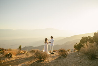 A couple reads each other their vows during their sunset elopement on top of Key's View in Joshua Tree, California.