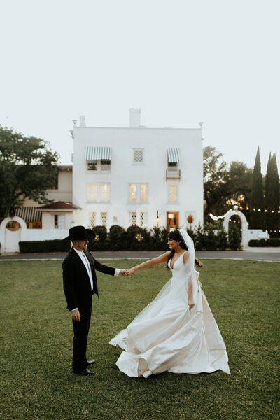 Bride and groom hold hands in courtyard