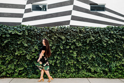 woman walking with ivy wall and mural