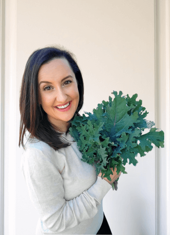 Jerusha Jantz Wellness Coach holding a bundle of kale