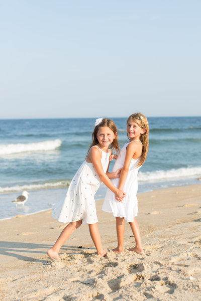girls holding hands on the beach