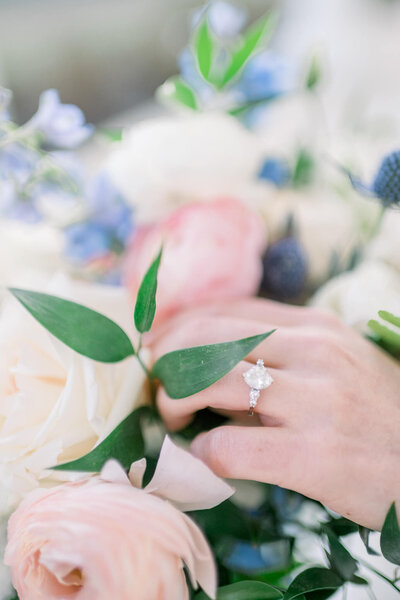 gorgeous detailed photograph of bride's oval shaped ring and pastel floral bouquet by arkansas wedding photographer