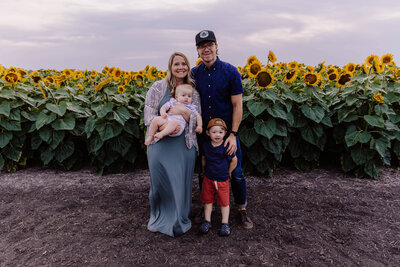 mom dad and kids in sunflower field