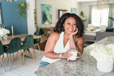 Black interior designer posing with her chin resting on her hand and a white coffee mug for her Nashville brand photos
