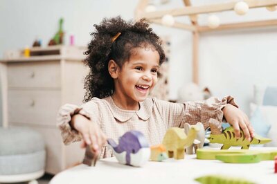 A child engaged in independent play, demonstrating the creativity and self-reliance encouraged by a supportive environment.