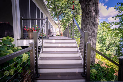 PVC deck staircase with contrasting risers and treads, with cable railing on the sides. 