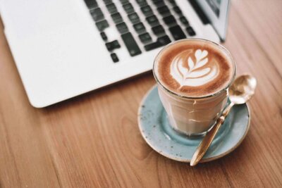 Kop koffie naast een laptop tijdens het bouwen van Showit websites.