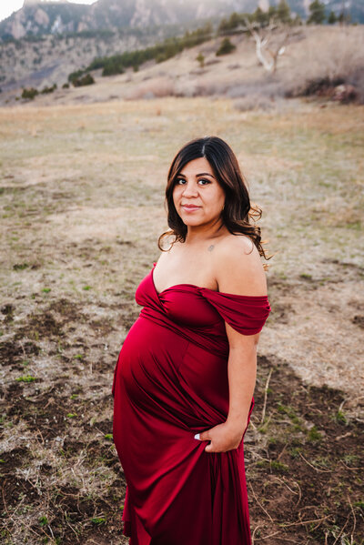 pregnant mom in red maternity dress for photos in Boulder Colorado