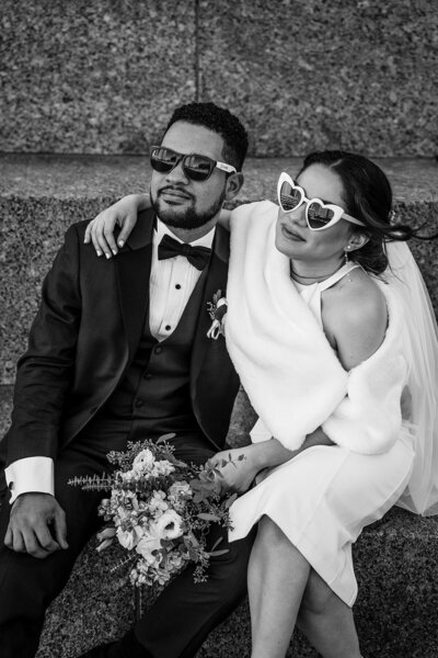 black and white portrait of a couple at city hall with fun sunglasses on
