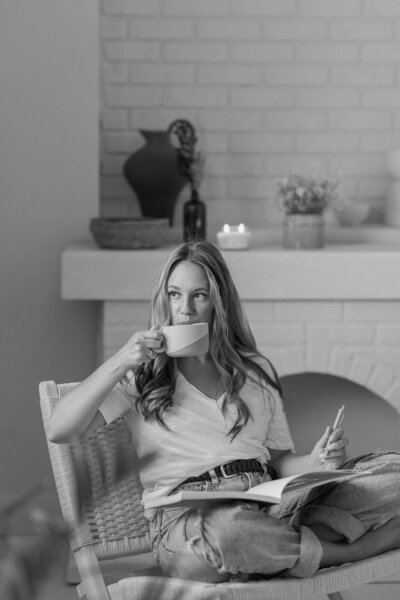 Martina Biljan, copywriter and creative brand strategist drinking coffee  writing in journal