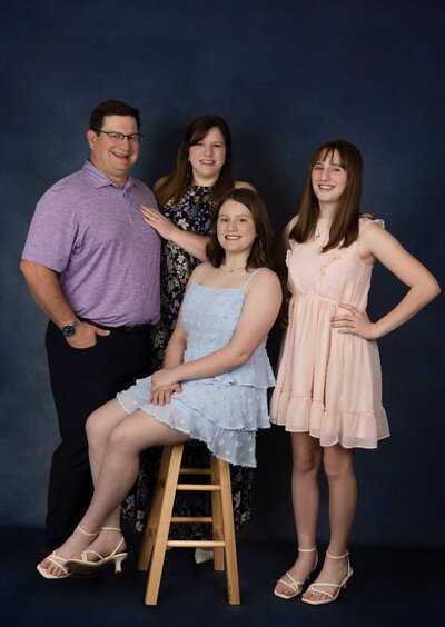 family-with-two-daughters-posing-in-studio