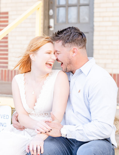 Happy fiances laughing during engagement photos