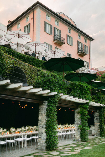 lake como italy pink building with dinner table under terrace
