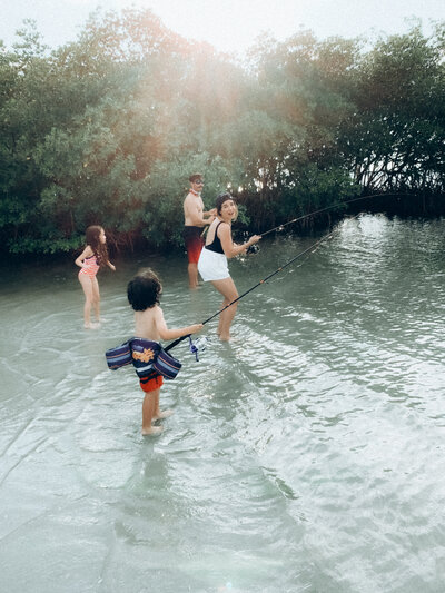 Kids standing in water fishing