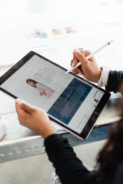 close up of showit website designer holding an ipad and apple pencil