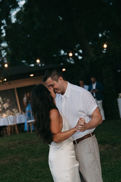 bride and groom embracing and sharing their first dance at twlight