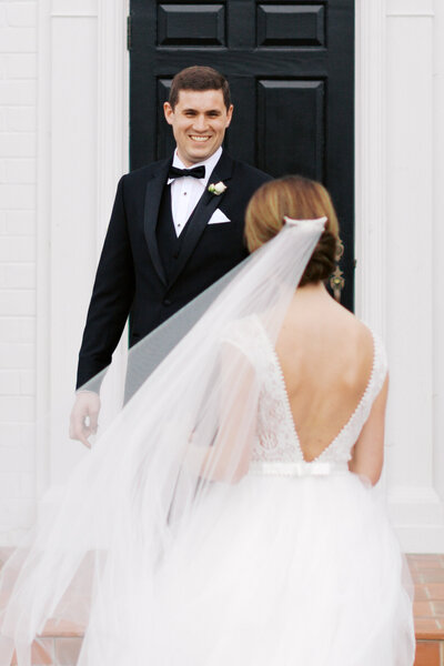 Groom smiling at bride during their first look at The Adams Estate in Lake Wales, Florida.