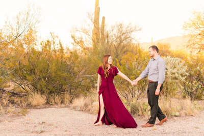 engaged couple walking together in desert